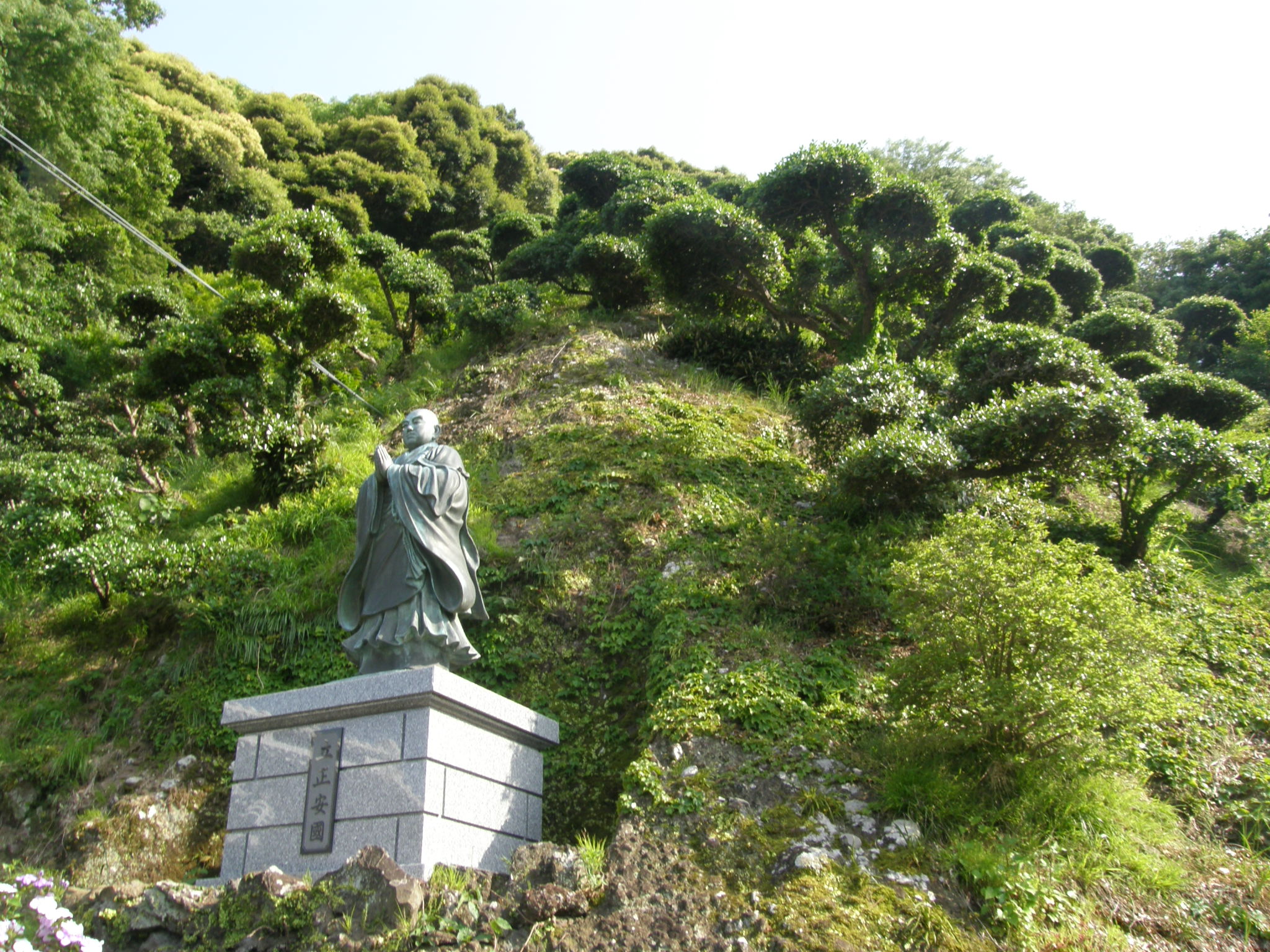 日蓮聖人像と緑豊かな境内